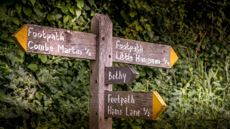 Signs for West Challacombe Bothy and footpaths to Combe Martin village (half a mile away) and Little Hangman Hill (a quarter of a mile away), Devon